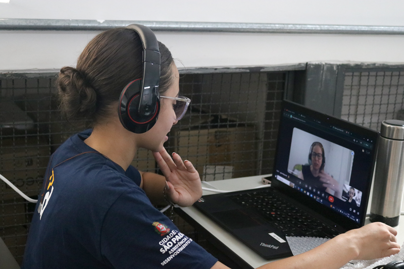 Mentora orientando jovens durante uma atividade em sala